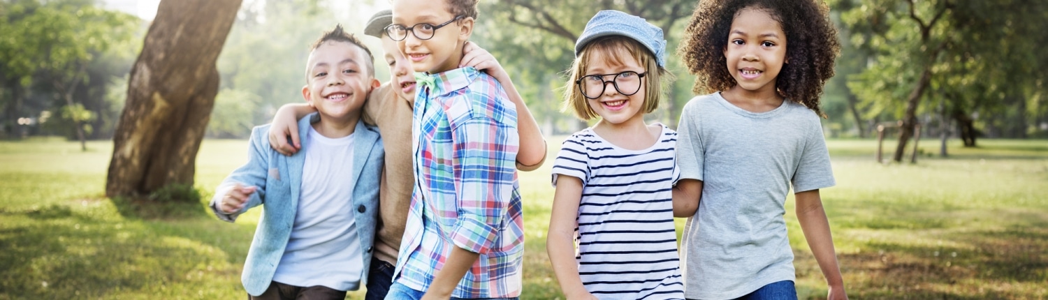 Five young happy children in a park setting