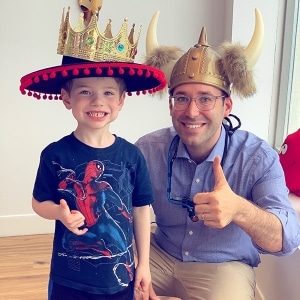 Dr. Noah and child patient wearing crazy hats.