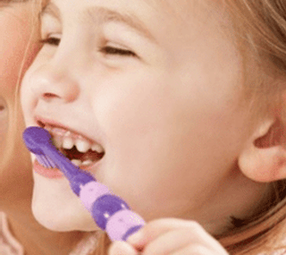 Young child brushing her own teeth